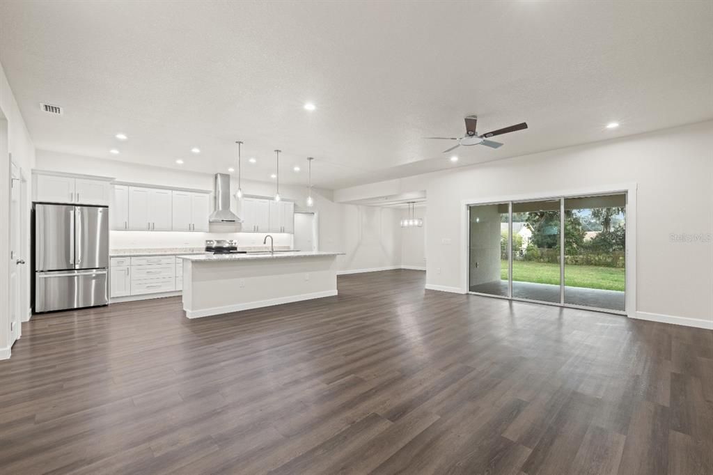 Empty room, Interior, Kitchen, Pendant Lights, Recessed Lighting, Stainless Steel Appliances, Wood Texture Flooring