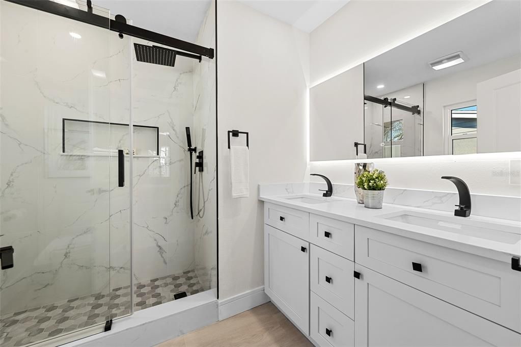 Bathroom, Dual Sink Vanities, Glass Shower, Interior, Marble Walls, Recessed Lighting, Wood Texture Flooring