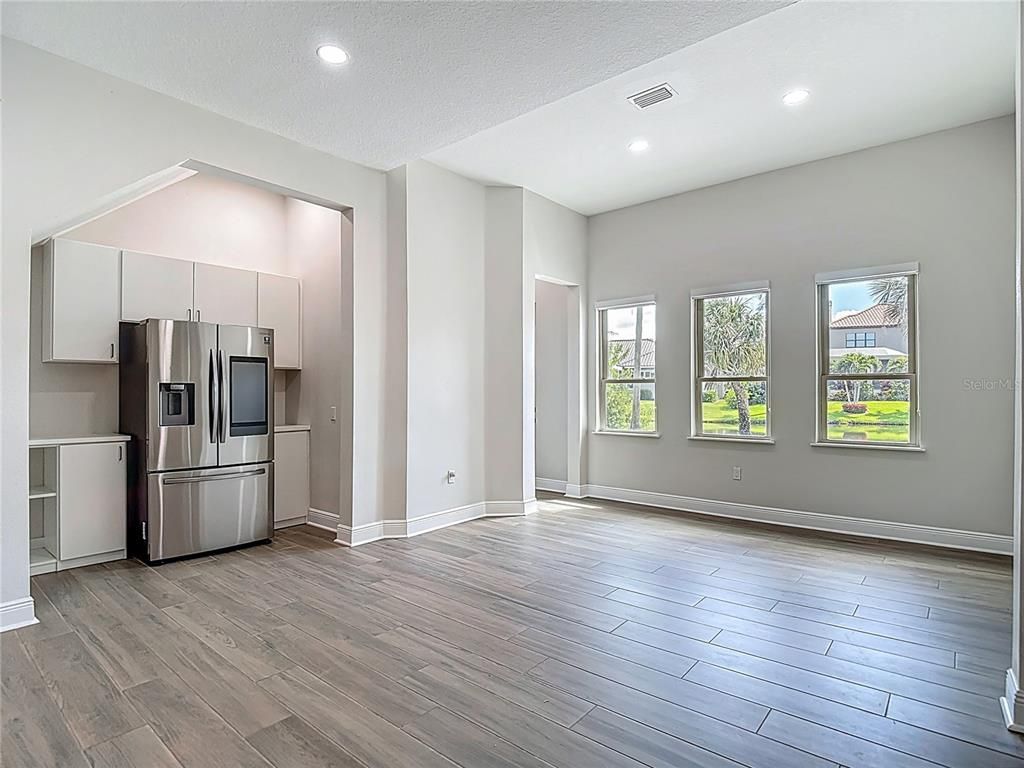 Empty room, Interior, Kitchen, Recessed Lighting, Stainless Steel Appliances, Wood Texture Flooring