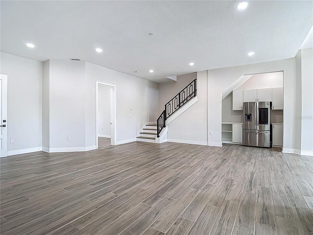 Empty room, Interior, Kitchen, Recessed Lighting, Stainless Steel Appliances, Wood Texture Flooring