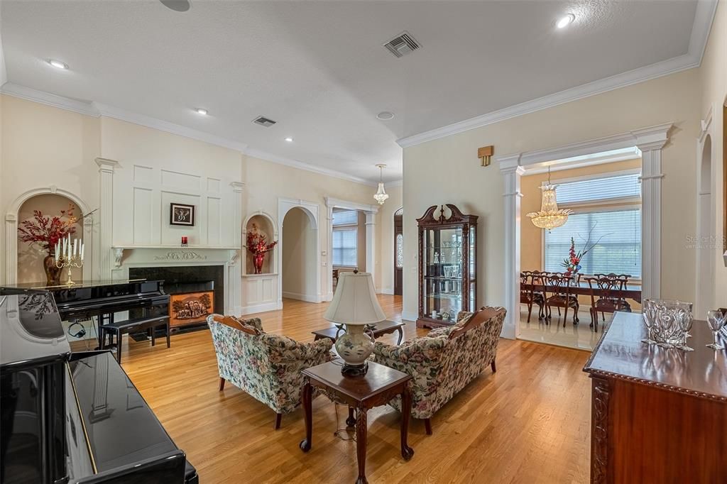 Chandelier, Dining room, Fireplace, Interior, Living room, Pendant Lights, Piano, Recessed Lighting, Wood Texture Flooring