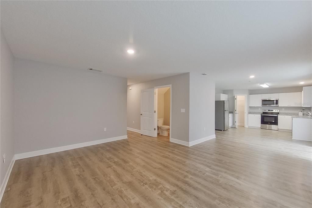 Empty room, Interior, Kitchen, Recessed Lighting, Stainless Steel Appliances, Wood Texture Flooring