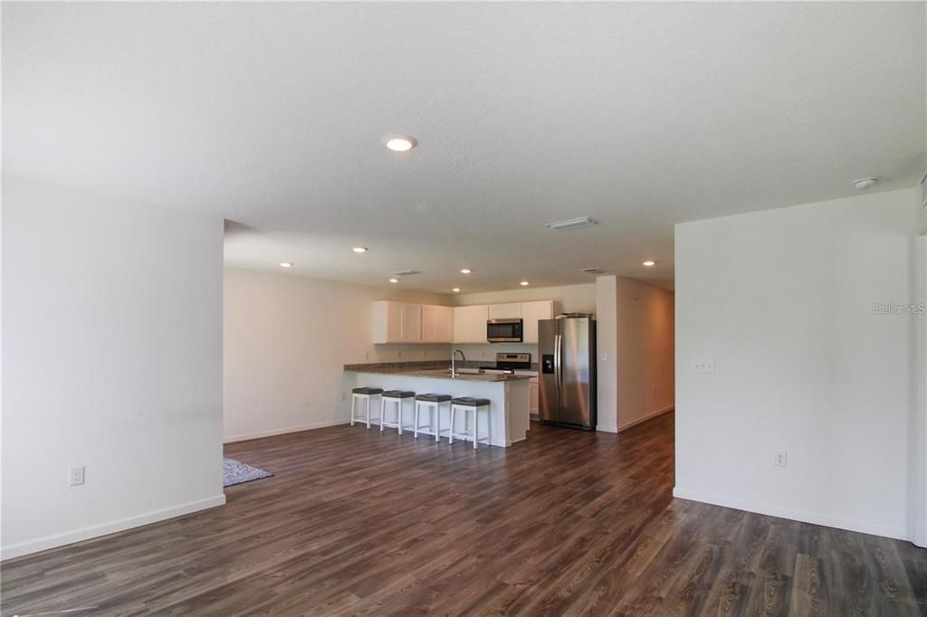 Empty room, Interior, Kitchen, Recessed Lighting, Stainless Steel Appliances, Wood Texture Flooring