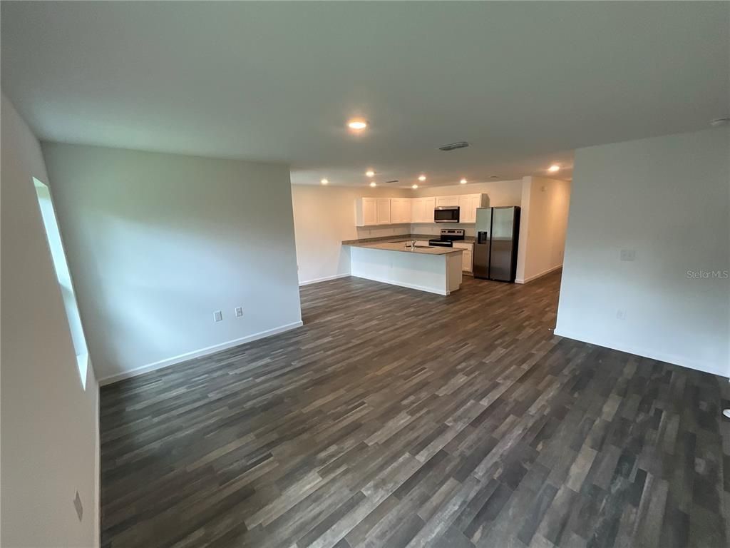 Empty room, Interior, Kitchen, Recessed Lighting, Stainless Steel Appliances, Wood Texture Flooring