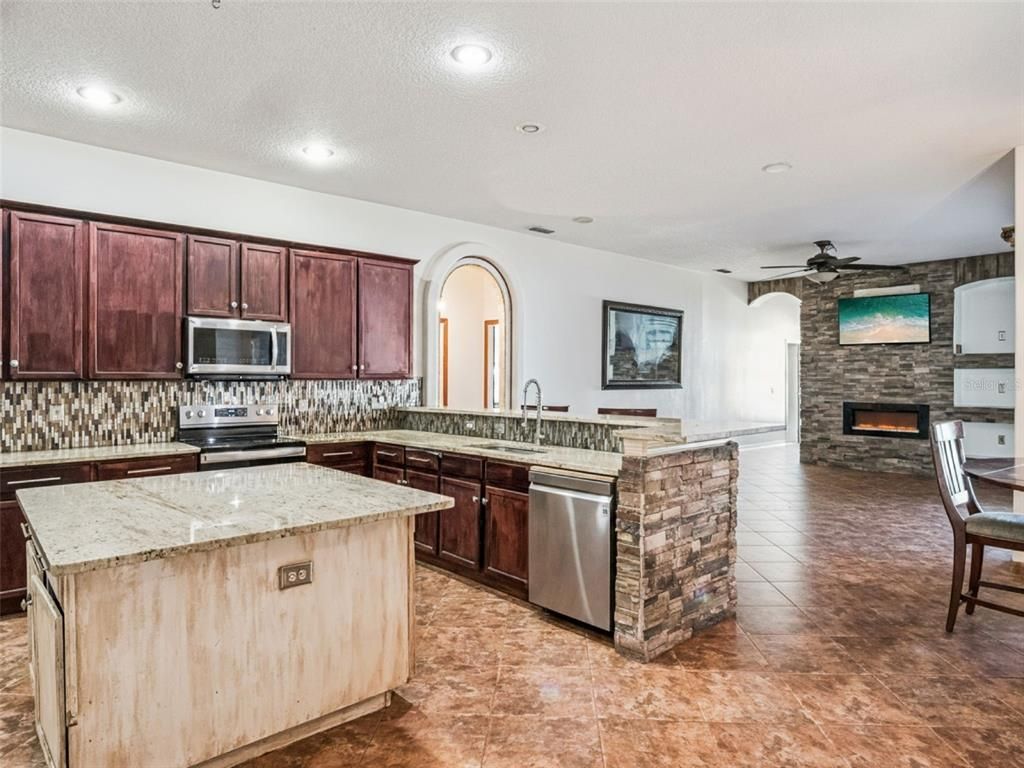 Fireplace, Interior, Kitchen, Recessed Lighting, Stainless Steel Appliances, Stone Walls