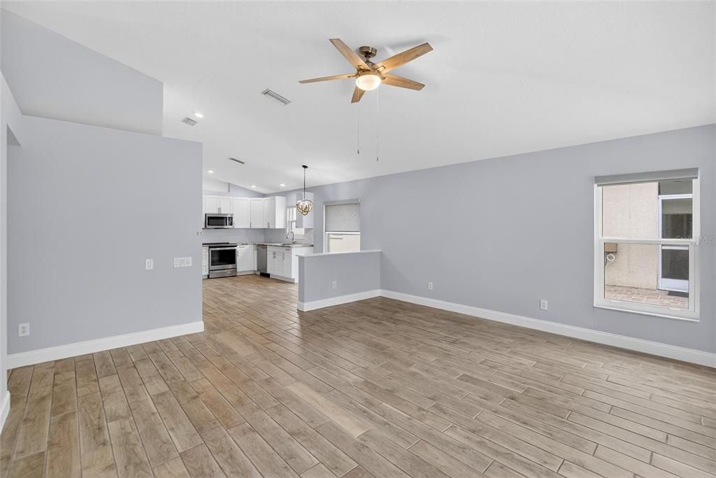 Empty room, Interior, Kitchen, Pendant Lights, Recessed Lighting, Stainless Steel Appliances, Wood Texture Flooring