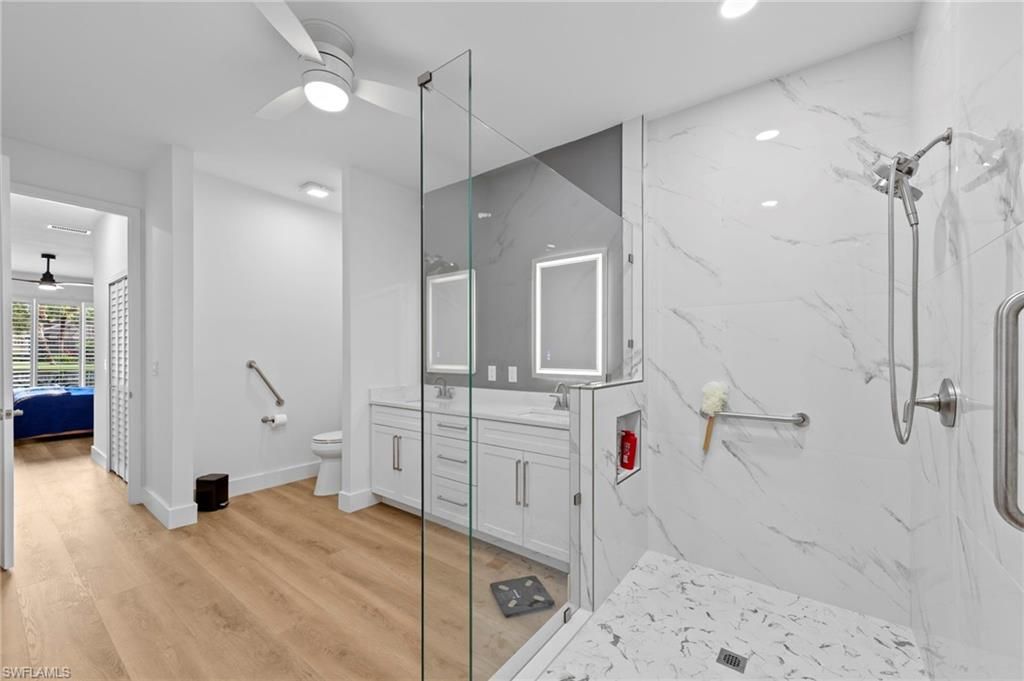 Bathroom, Dual Sink Vanities, Glass Shower, Interior, Marble Walls, Recessed Lighting, Wood Texture Flooring
