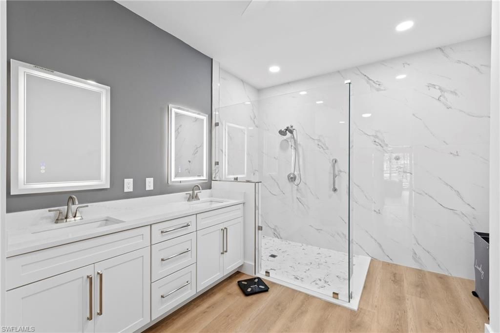 Bathroom, Dual Sink Vanities, Glass Shower, Interior, Marble Walls, Recessed Lighting, Wood Texture Flooring