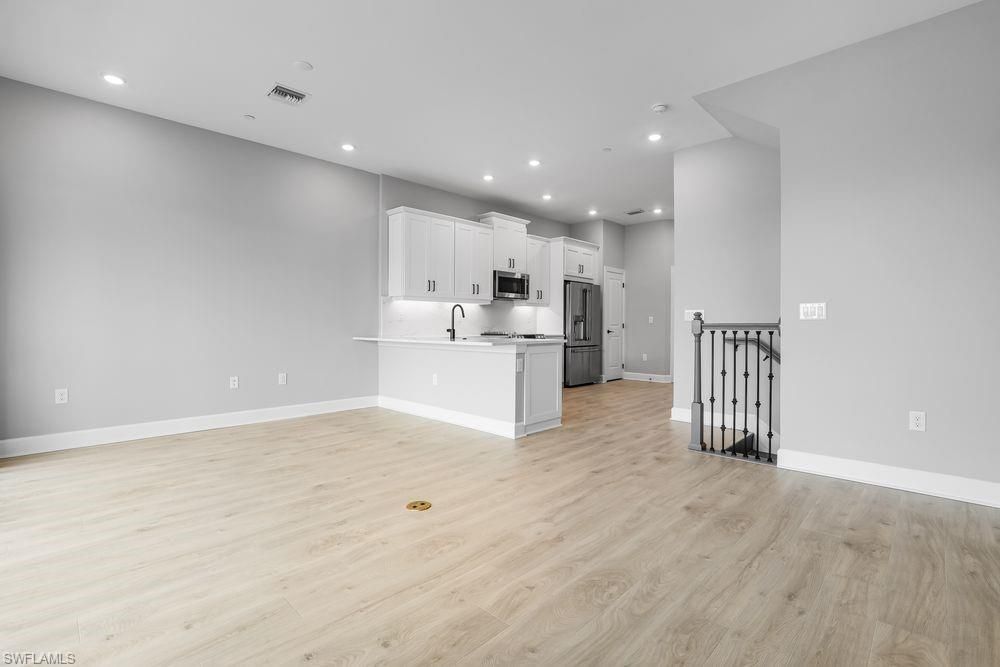 Empty room, Interior, Kitchen, Recessed Lighting, Stainless Steel Appliances, Wood Texture Flooring