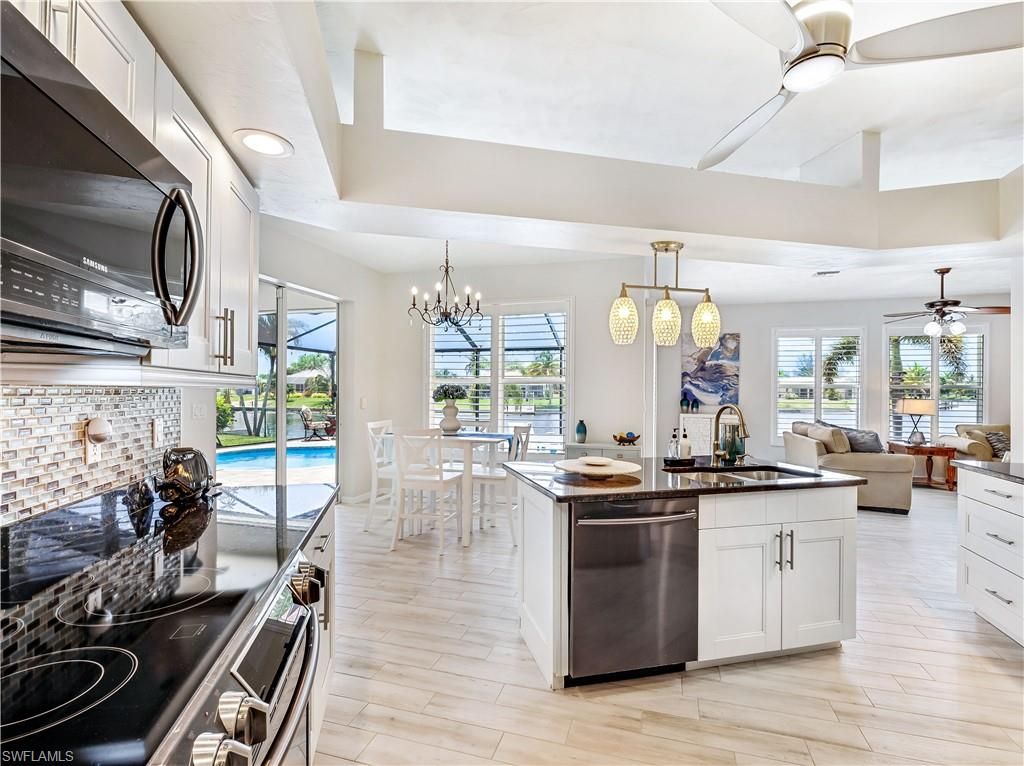 Chandelier, Dining room, Interior, Kitchen, Living room, Pendant Lights, Recessed Lighting, Stainless Steel Appliances, Wood Texture Flooring