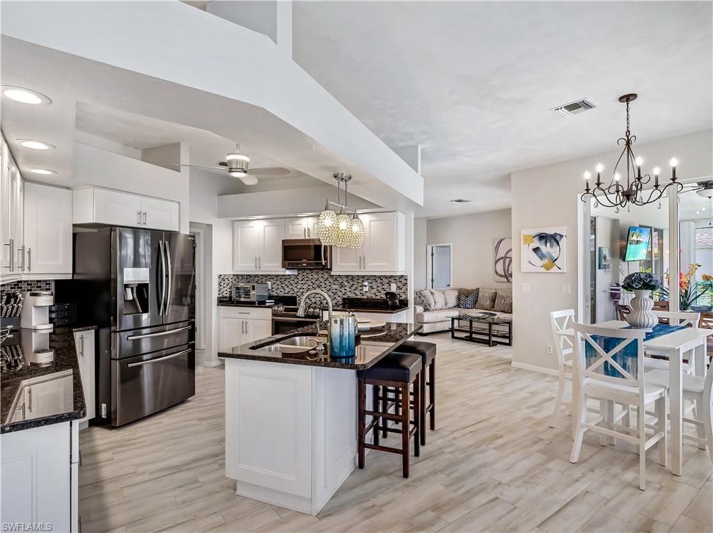 Chandelier, Dining room, Interior, Kitchen, Living room, Pendant Lights, Recessed Lighting, Stainless Steel Appliances, Wood Texture Flooring