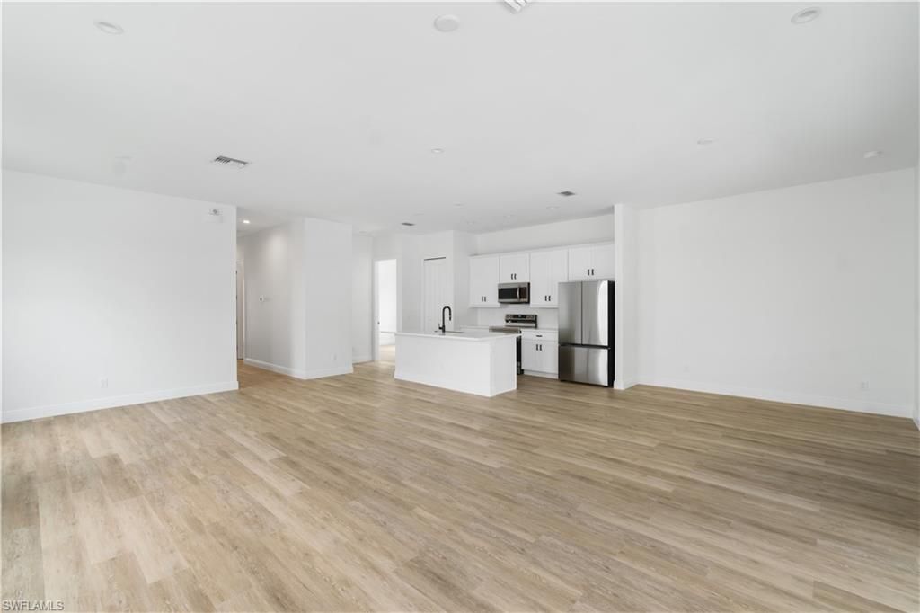 Empty room, Interior, Kitchen, Recessed Lighting, Stainless Steel Appliances, Wood Texture Flooring