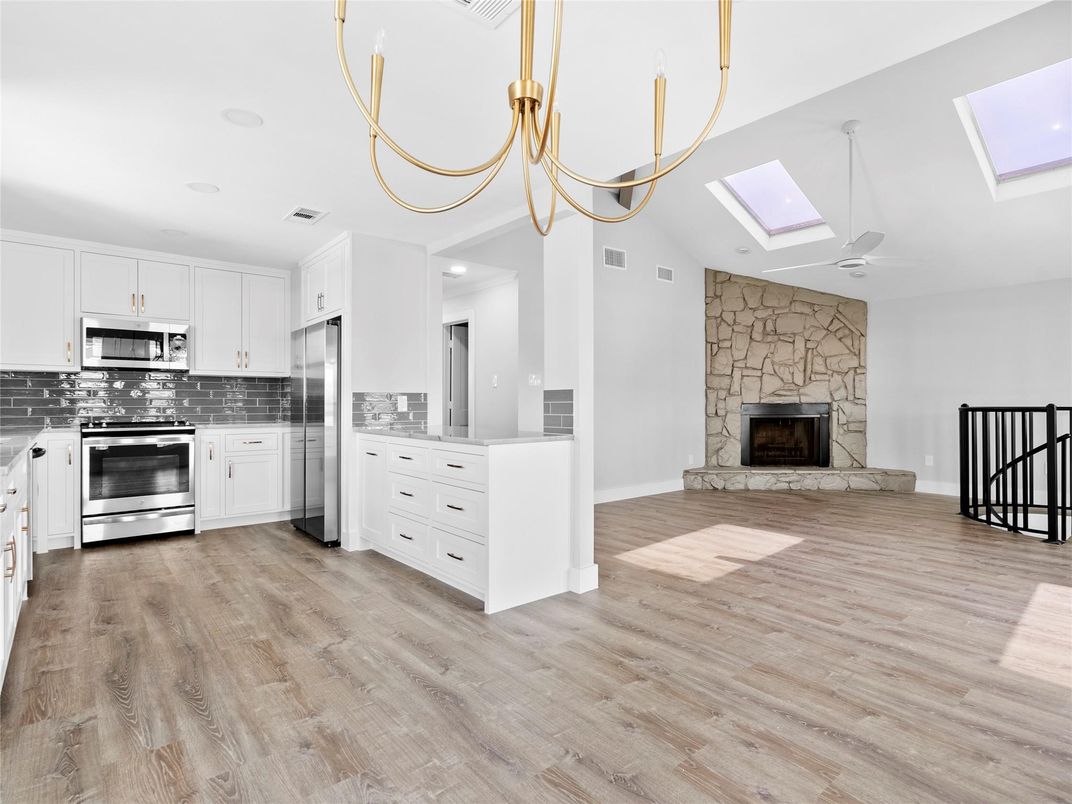 Fireplace, Interior, Kitchen, Recessed Lighting, Stainless Steel Appliances, Stone Walls, Wood Texture Flooring