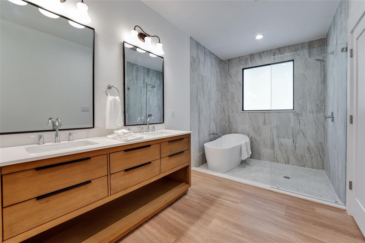 Bathroom, Dual Sink Vanities, Free Standing Baths, Glass Shower, Interior, Marble Walls, Recessed Lighting, Wood Texture Flooring