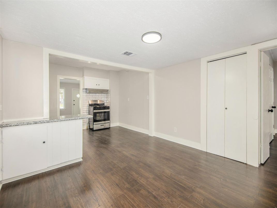 Empty room, Interior, Kitchen, Recessed Lighting, Stainless Steel Appliances, Wood Texture Flooring