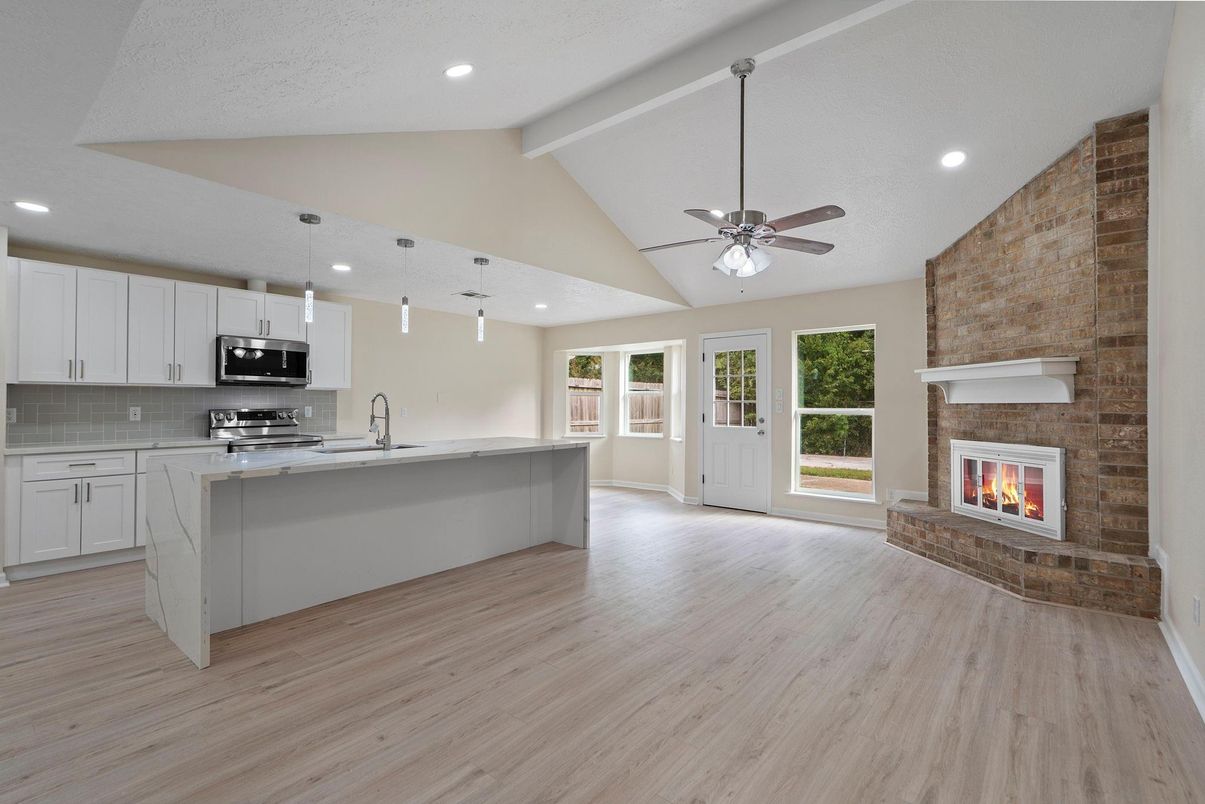 Fireplace, Interior, Kitchen, Pendant Lights, Recessed Lighting, Stainless Steel Appliances, Stone Walls, Wood Texture Flooring