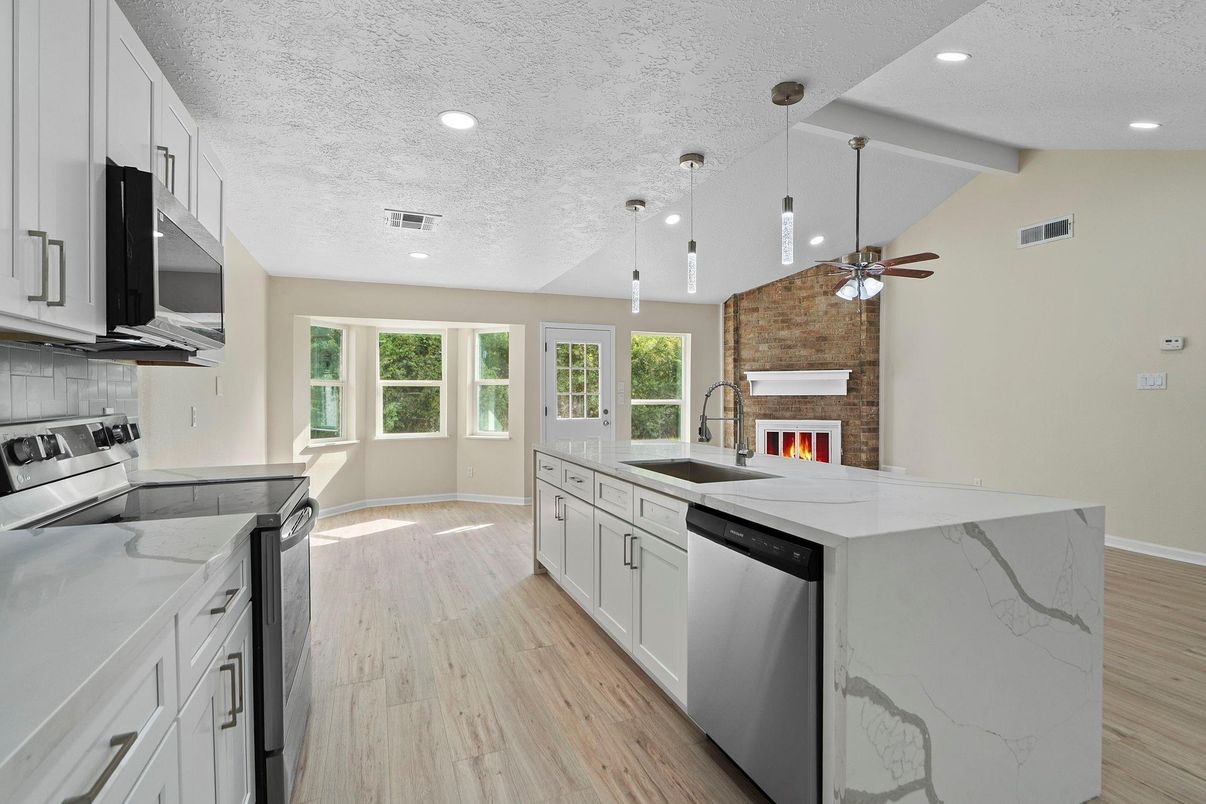 Fireplace, Interior, Kitchen, Pendant Lights, Recessed Lighting, Stainless Steel Appliances, Stone Walls, Wood Texture Flooring