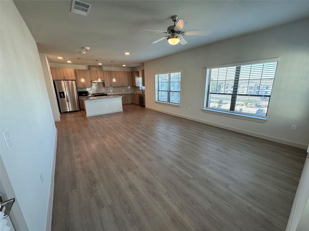 Empty room, Interior, Kitchen, Recessed Lighting, Stainless Steel Appliances, Wood Texture Flooring