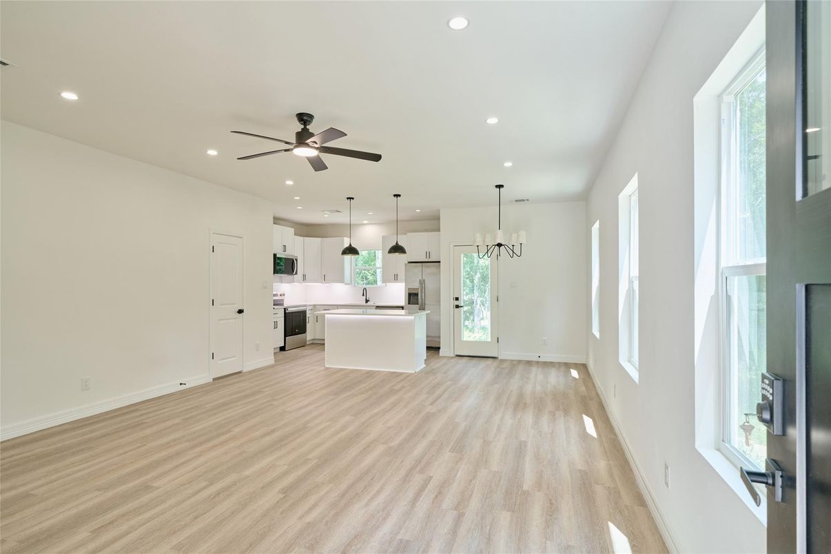 Empty room, Interior, Kitchen, Pendant Lights, Recessed Lighting, Stainless Steel Appliances, Wood Texture Flooring