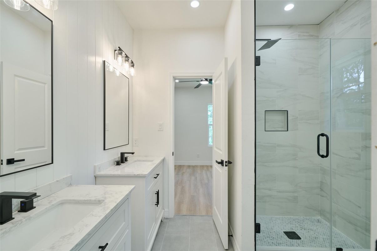Bathroom, Dual Sink Vanities, Glass Shower, Interior, Marble Walls, Recessed Lighting, Wood Texture Flooring
