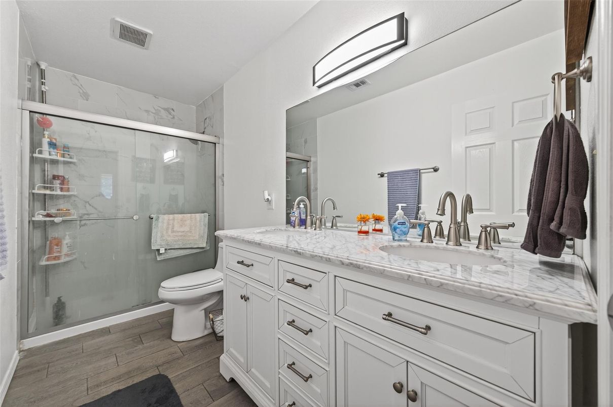 Bathroom, Dual Sink Vanities, Glass Shower, Interior, Marble Walls, Wood Texture Flooring