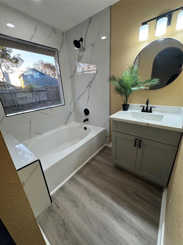Bathroom, Dual Sink Vanities, Interior, Marble Walls, Recessed Lighting, Wood Texture Flooring
