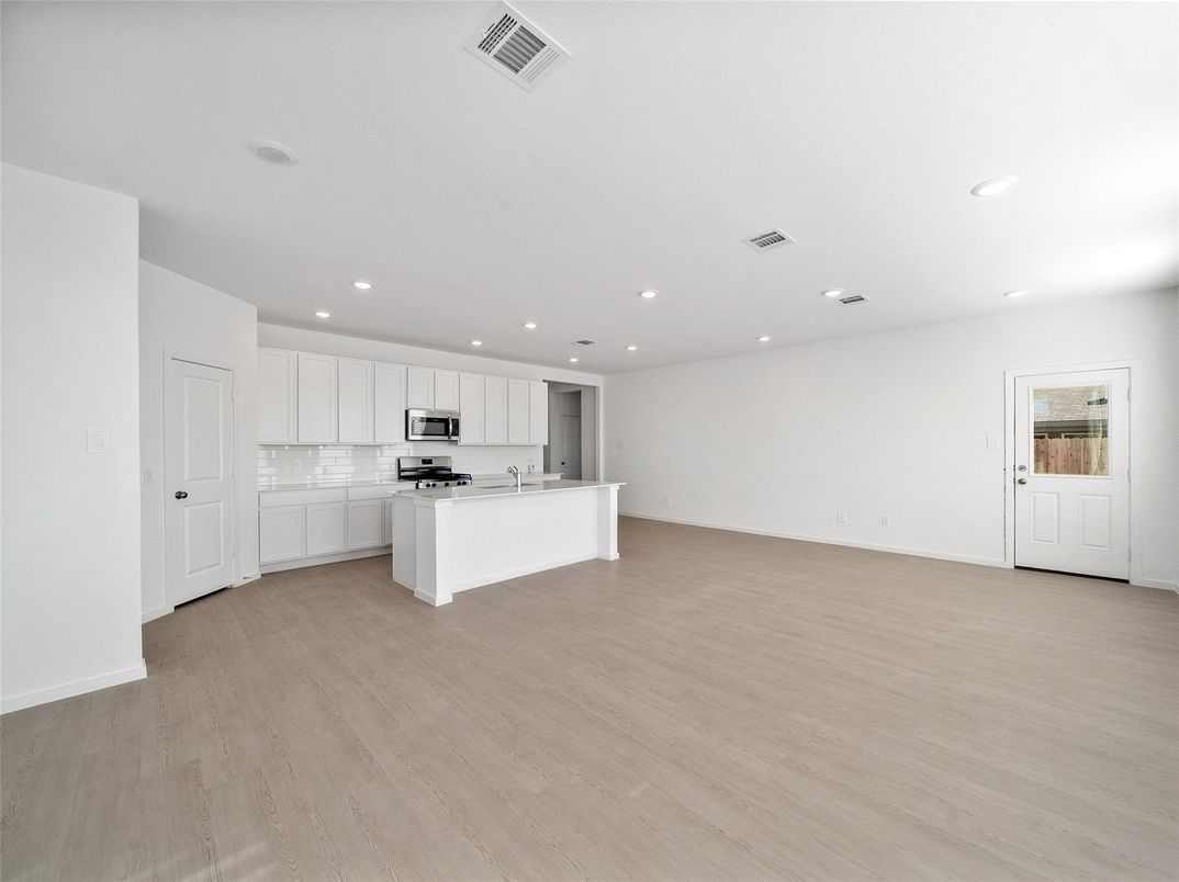 Empty room, Interior, Kitchen, Recessed Lighting, Stainless Steel Appliances, Wood Texture Flooring