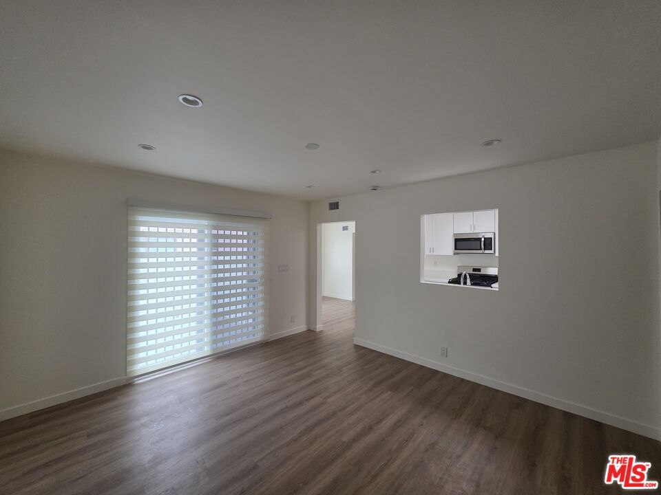Empty room, Interior, Kitchen, Recessed Lighting, Stainless Steel Appliances, Wood Texture Flooring