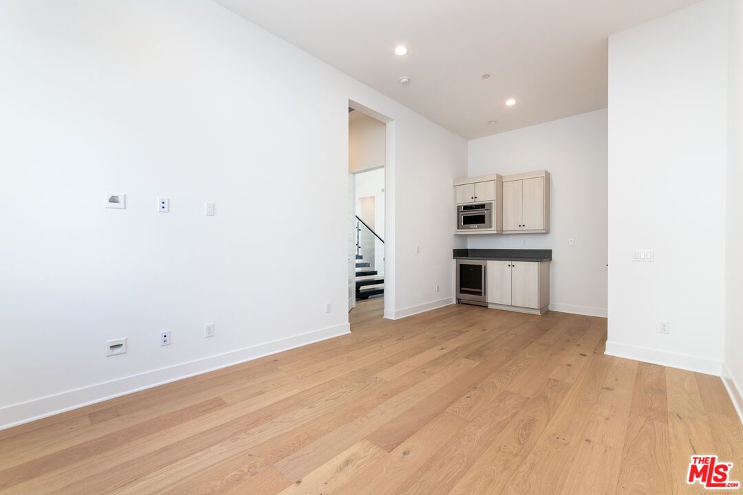 Empty room, Interior, Kitchen, Recessed Lighting, Stainless Steel Appliances, Wood Texture Flooring