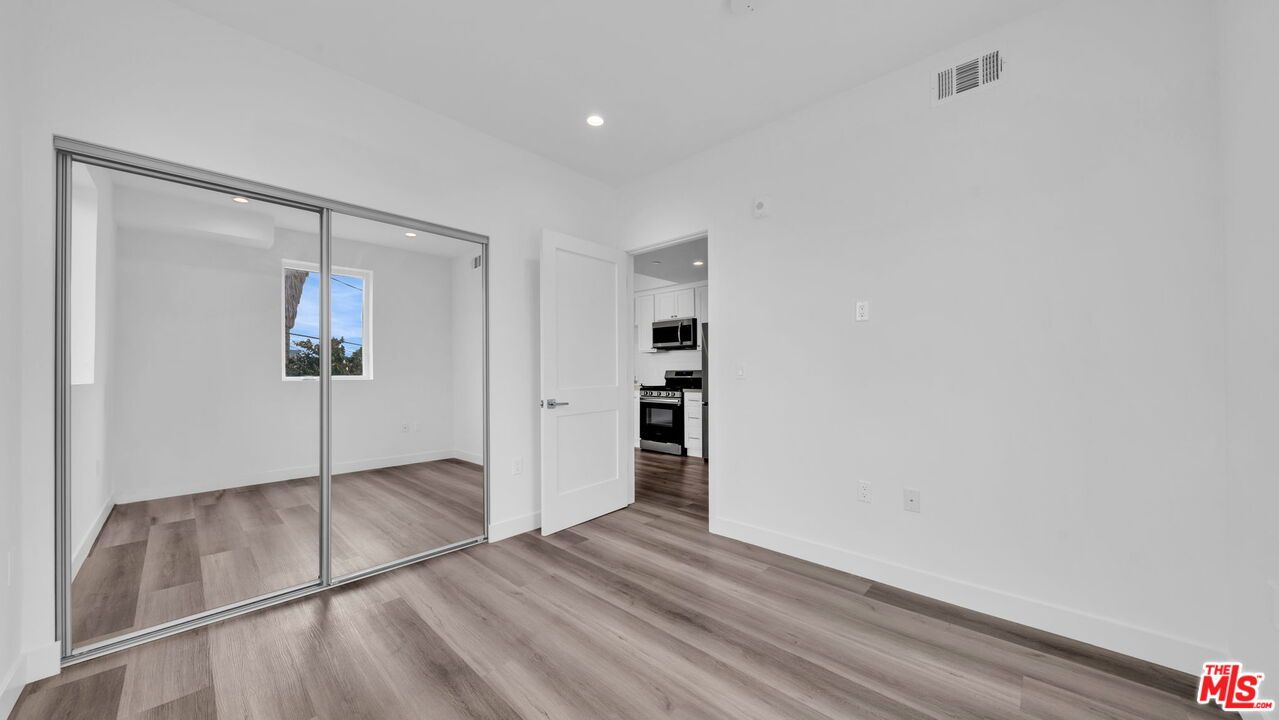 Empty room, Interior, Kitchen, Recessed Lighting, Stainless Steel Appliances, Wood Texture Flooring