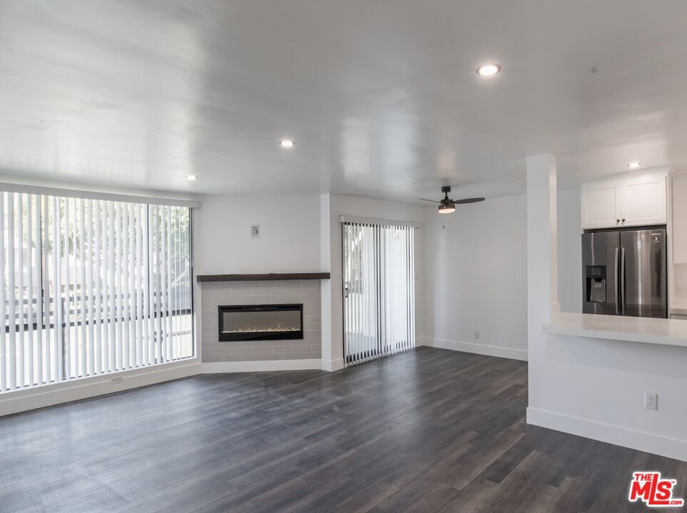 Empty room, Fireplace, Interior, Kitchen, Recessed Lighting, Stainless Steel Appliances, Wood Texture Flooring