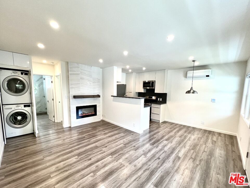 Empty room, Fireplace, Interior, Kitchen, Pendant Lights, Recessed Lighting, Washer, Wood Texture Flooring