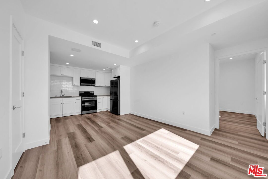 Empty room, Interior, Kitchen, Recessed Lighting, Stainless Steel Appliances, Wood Texture Flooring