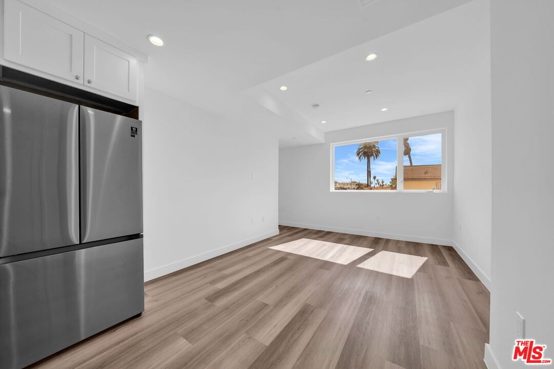 Empty room, Interior, Kitchen, Recessed Lighting, Stainless Steel Appliances, Wood Texture Flooring