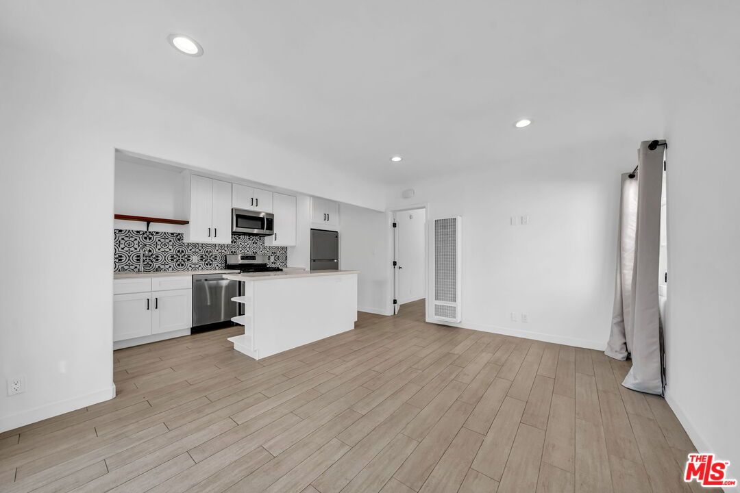 Empty room, Interior, Kitchen, Recessed Lighting, Stainless Steel Appliances, Wood Texture Flooring