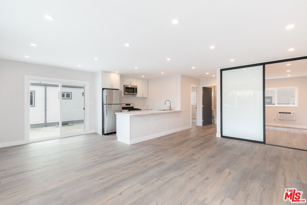 Empty room, Interior, Kitchen, Recessed Lighting, Stainless Steel Appliances, Wood Texture Flooring
