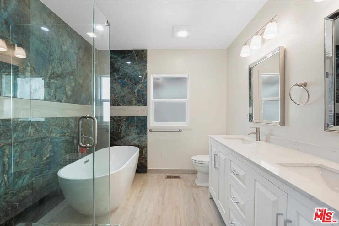 Bathroom, Dual Sink Vanities, Free Standing Baths, Glass Shower, Interior, Marble Walls, Recessed Lighting, Wood Texture Flooring