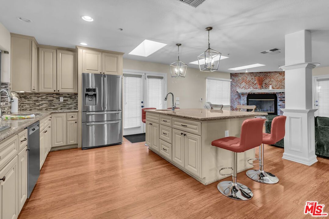 Fireplace, Interior, Kitchen, Pendant Lights, Recessed Lighting, Stainless Steel Appliances, Stone Walls, Wood Texture Flooring