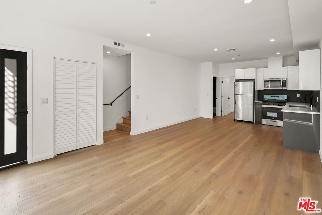 Empty room, Interior, Kitchen, Recessed Lighting, Stainless Steel Appliances, Wood Texture Flooring