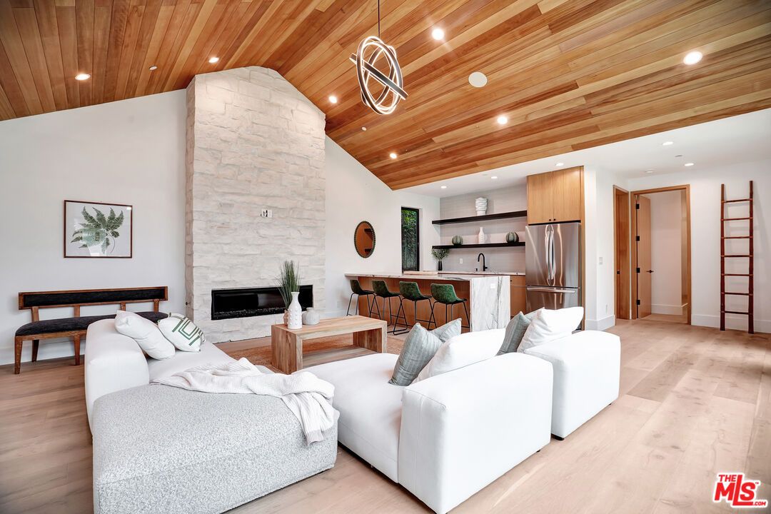 Fireplace, Interior, Kitchen, Living room, Pendant Lights, Recessed Lighting, Stainless Steel Appliances, Stone Walls, Wooden Ceilings, Wood Texture Flooring