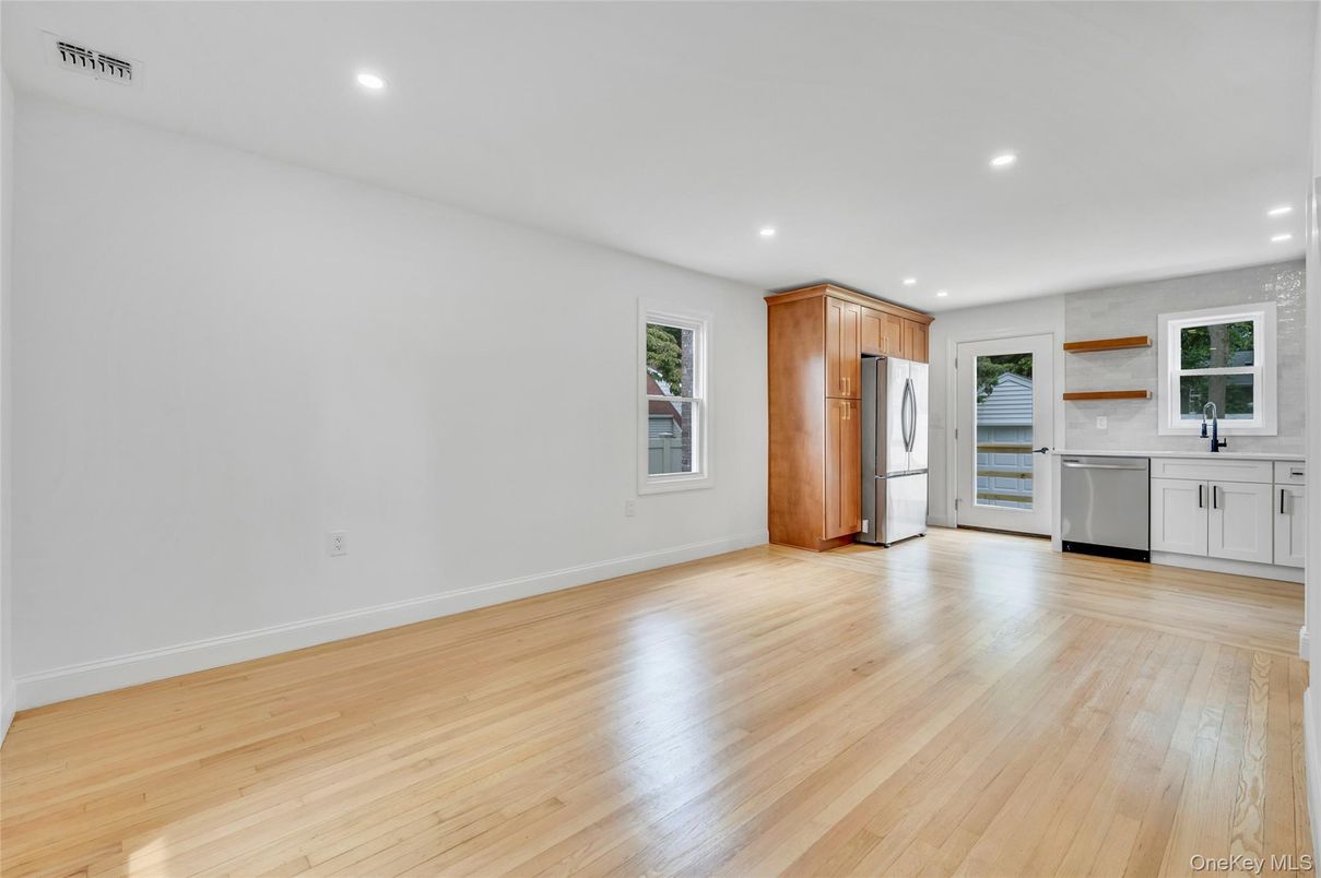 Empty room, Interior, Kitchen, Recessed Lighting, Stainless Steel Appliances, Wood Texture Flooring