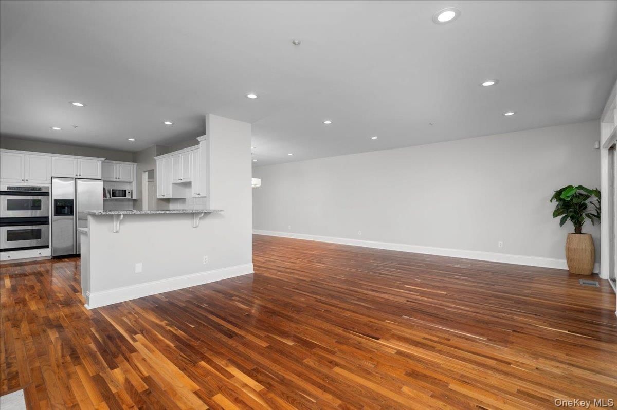 Empty room, Interior, Kitchen, Recessed Lighting, Stainless Steel Appliances, Wood Texture Flooring