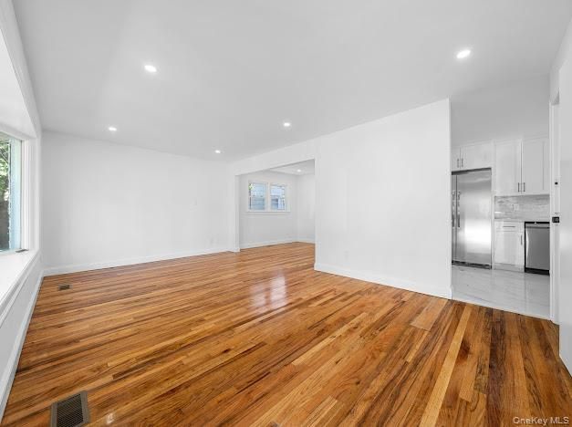 Empty room, Interior, Kitchen, Recessed Lighting, Stainless Steel Appliances, Wood Texture Flooring