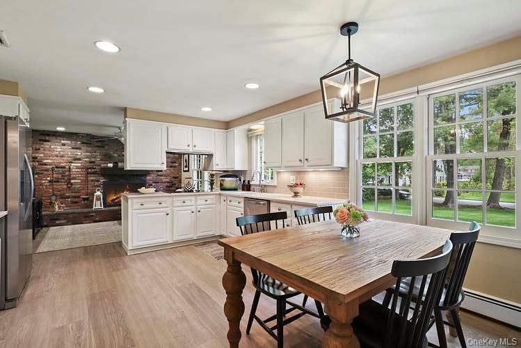 Dining room, Fireplace, Interior, Kitchen, Pendant Lights, Recessed Lighting, Stainless Steel Appliances, Stone Walls, Wood Texture Flooring