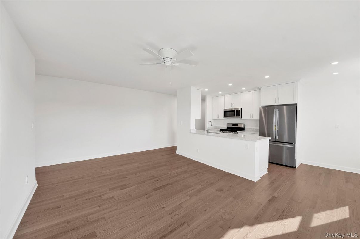 Empty room, Interior, Kitchen, Recessed Lighting, Stainless Steel Appliances, Wood Texture Flooring