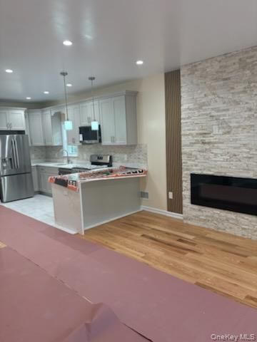 Fireplace, Interior, Kitchen, Pendant Lights, Recessed Lighting, Stainless Steel Appliances, Stone Walls, Wood Texture Flooring