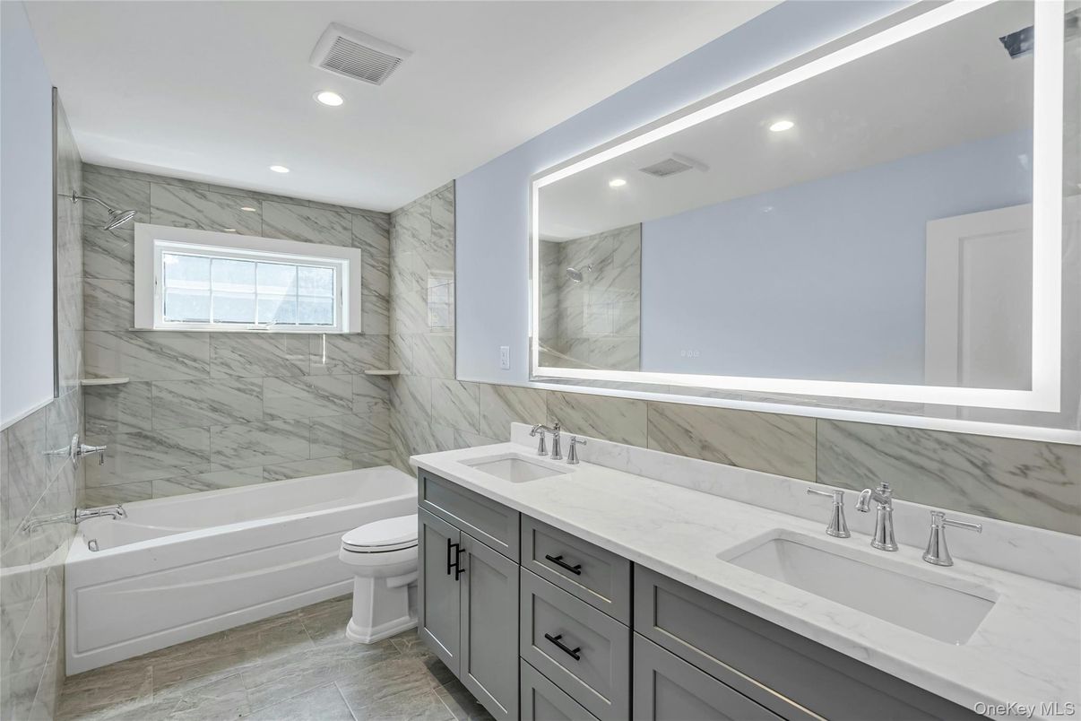 Bathroom, Dual Sink Vanities, Interior, Marble, Marble Walls, Recessed Lighting, Wood Texture Flooring