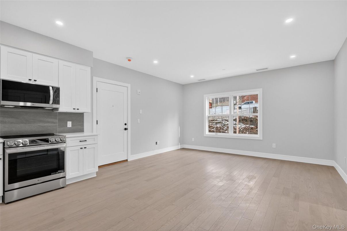 Empty room, Interior, Kitchen, Recessed Lighting, Stainless Steel Appliances, Wood Texture Flooring
