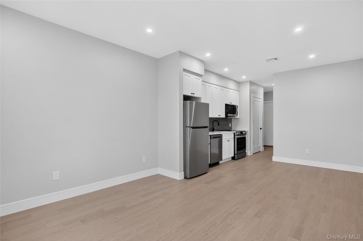 Empty room, Interior, Kitchen, Recessed Lighting, Stainless Steel Appliances, Wood Texture Flooring