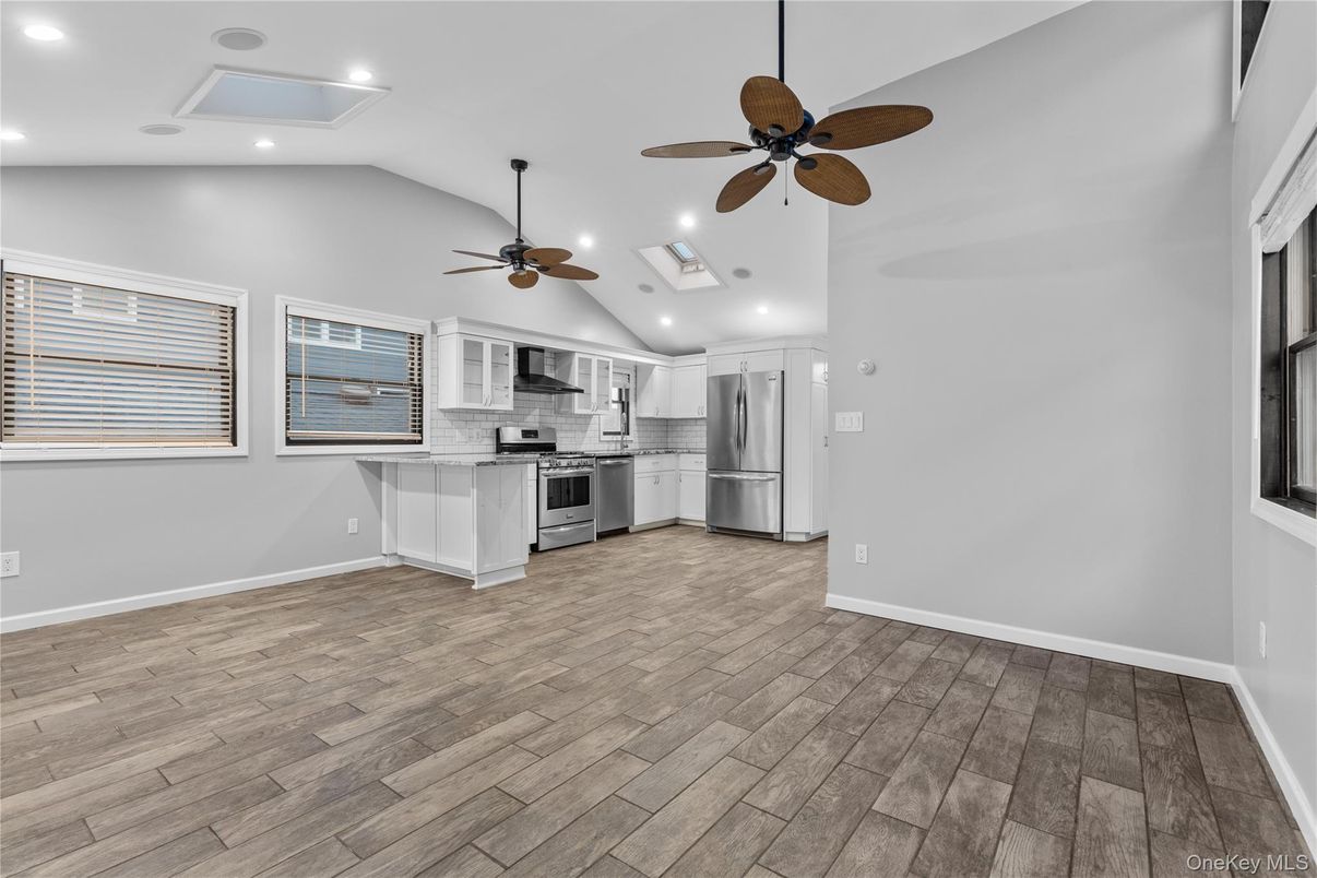 Empty room, Interior, Kitchen, Recessed Lighting, Stainless Steel Appliances, Wood Texture Flooring